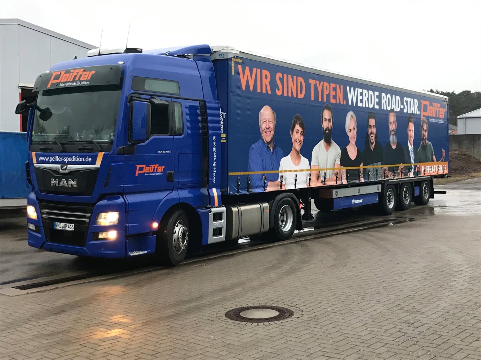 Blauer Sattelzug mit großflächig bedruckter LKW-Plane