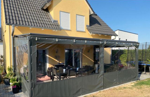 Terrasseneinfassung aus grauer Plane mit transparenten Sichtfenstern, Gesamtansicht
