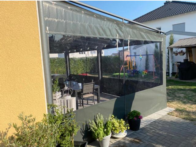 Terrasseneinfassung aus grauer Plane mit transparenten Sichtfenstern
